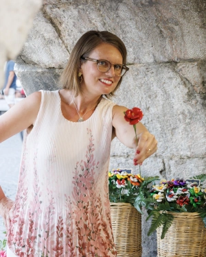 Simone mit einer Rose in der Hand mit der überreichen-Geste 